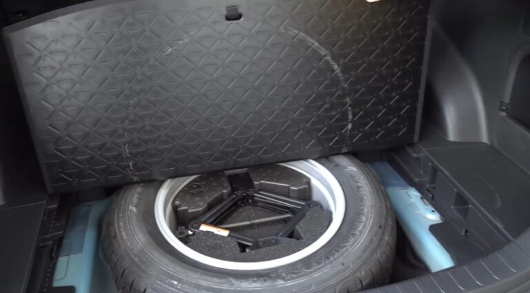 The spare tire and jack are neatly stored beneath the cargo area floor